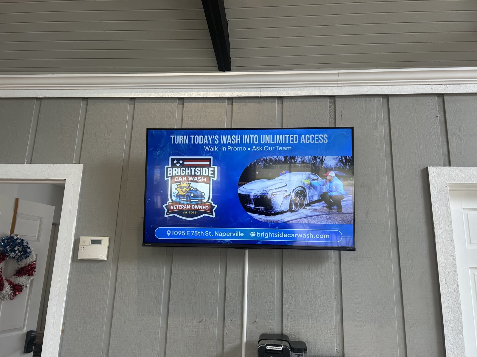 Indoor digital advertising screen at Brightside Car Wash in Naperville