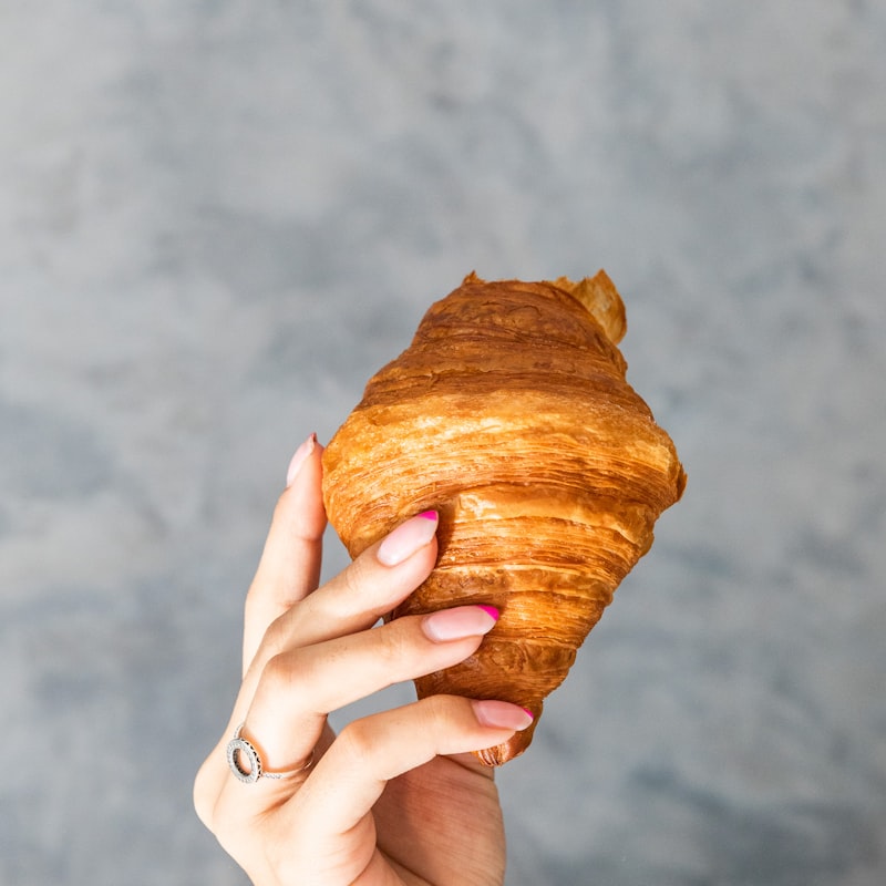 Almond croissant held in hand