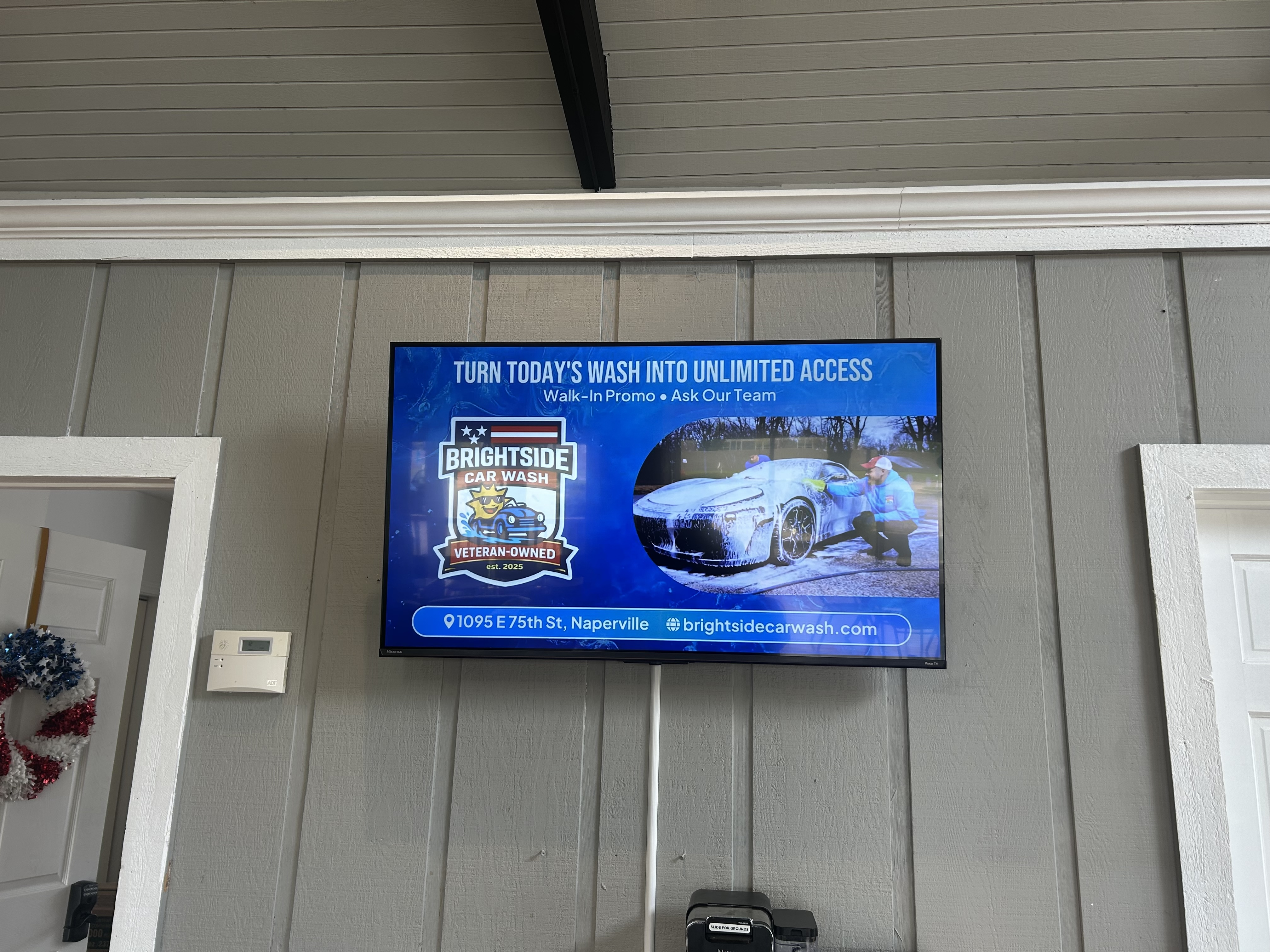 Indoor digital advertising screen at Brightside Car Wash in Naperville