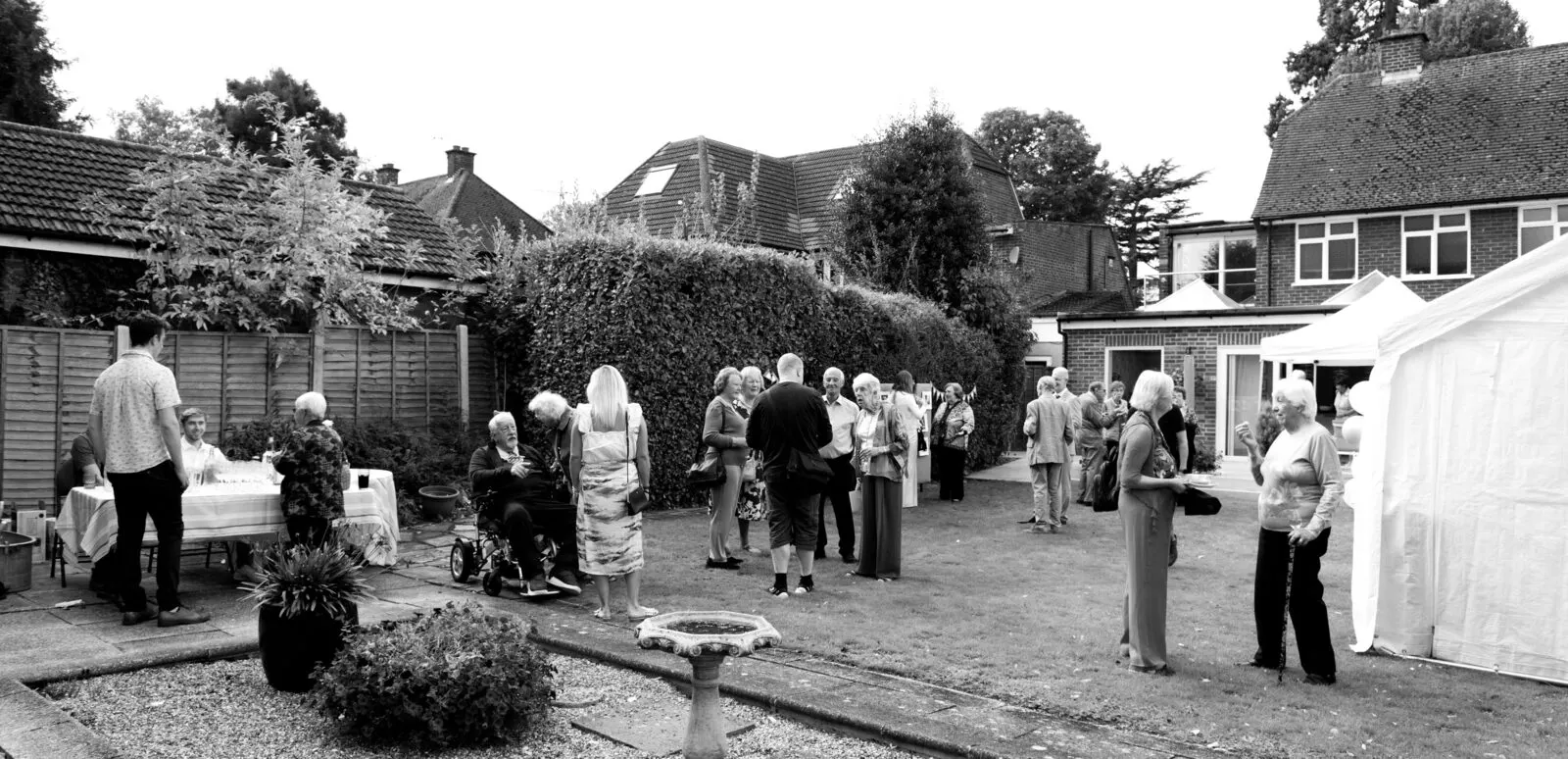 Guests enjoying a garden celebration beside a Moments Covered marquee