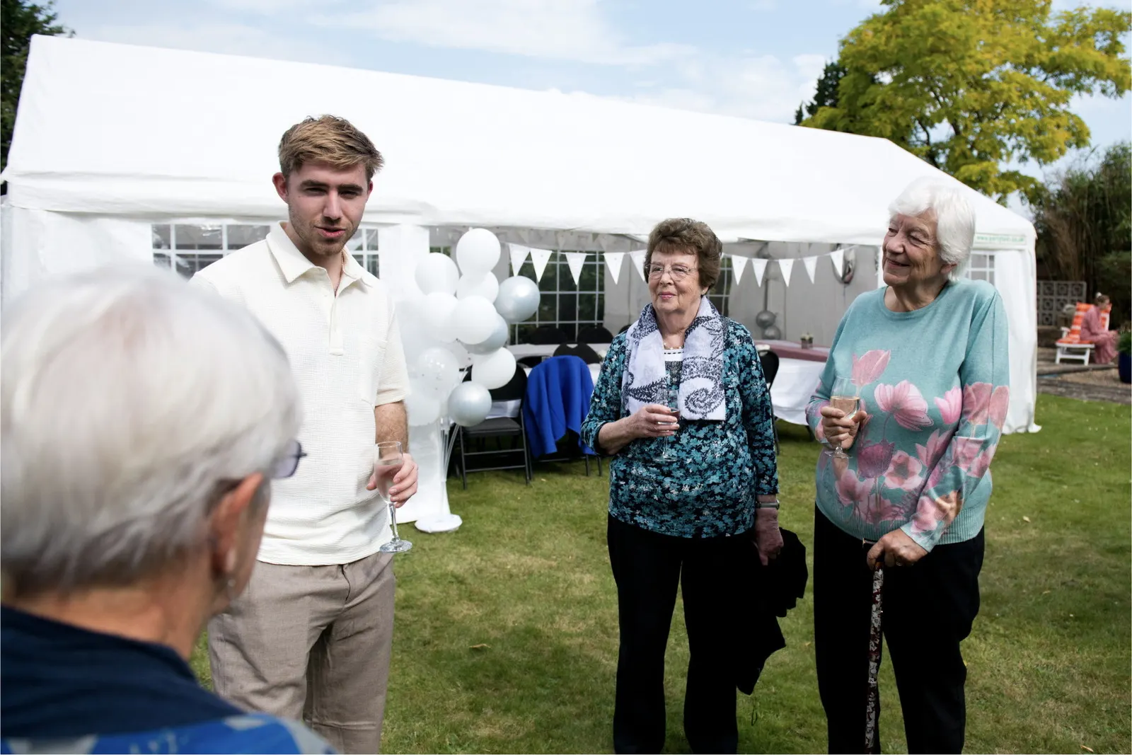 Guests gathering outside a covered family garden celebration