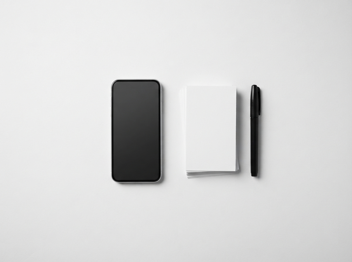 Monochrome studio flatlay of a smartphone and content planning materials